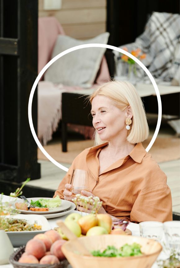 Femme mature, souriante à table - alimentation ménopause