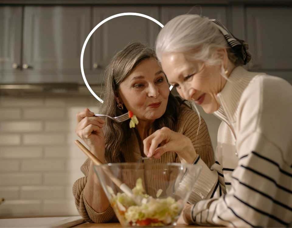 Femmes matures souriantes (ménopause) qui partagent un repas