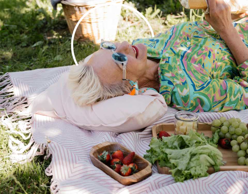 Femme périménopause souriante allongée sur une nappe de pique-nique