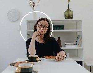 Femme assise à table devant son assiette mais dépitée - Perdre du poids - Marina Alves diététique angers