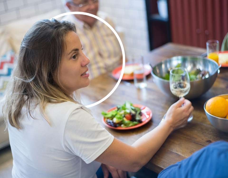 Femme souriante à table, moment convival - Marina Alves diététique - bien dans son corps et son assiette
